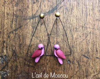 Designer earrings featuring a colorful bird on a wire, handmade, with a stainless steel base.