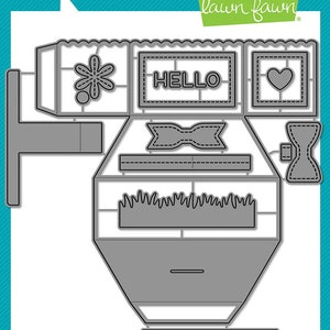 May include: A die-cut set for crafting a pop-up card featuring a house with a flower, a heart, a bow, and the word "HELLO". The set is made by Lawn Fawn and includes a platform pop-up.