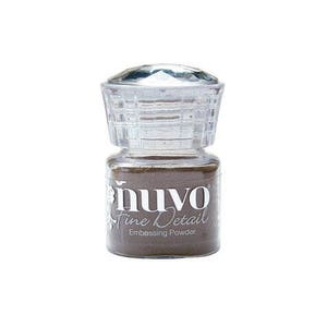 May include: A clear glass jar with a diamond-shaped lid filled with brown embossing powder. The jar is labeled "nuvo Fine Detail Embossing Powder".