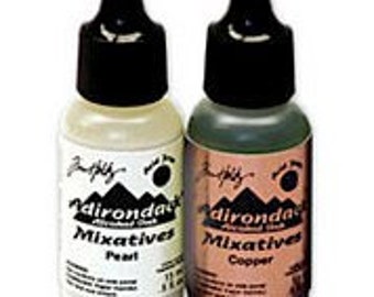 May include: Two bottles of Adirondack Mixatives alcohol inks, one in Peat and one in Copper. The bottles are clear glass with black dropper tops and white labels with the Adirondack Mixatives logo.