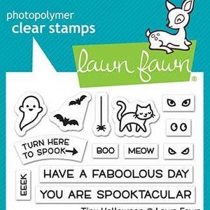 Op de afbeelding: Transparante fotopolymeer stempels met Halloween-thema ontwerpen. Inclusief een spook, vleermuizen, een kat en zinnen als "Turn Here to Spook" en "Have a Faboolous Day". De set bevat ook een hert en het Lawn Fawn logo.