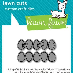 Peut inclure: Une carte bleu sarcelle et blanche avec le texte "lawn cuts" et "custom craft dies". L'image présente une illustration de cerf et une bannière verte avec les mots "lawn fawn". En dessous, des formes découpées de bulbes.