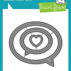 May include: Gray metal craft die set with a speech bubble design, featuring a heart shape in the center. The die set includes the text "lawn cuts" and "custom craft dies". The brand name "lawn fawn" is also visible.