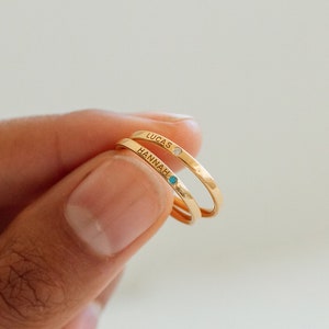 Gold name rings with blue and white gemstones, 'Hannah' and 'Lucas'