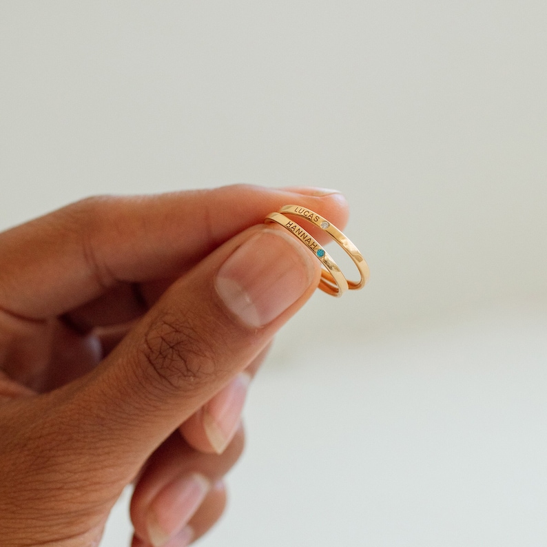 Gold name rings with blue and white gemstones, 'Hannah' and 'Lucas'