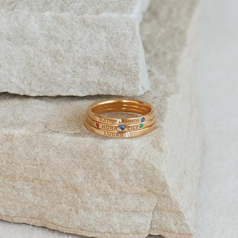 Three minimalist stacking rings placed on a natural stone background