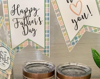 May include: A Father's Day celebration set featuring two 10 oz Yeti Rambler lowball tumblers, a Starbucks gift card, a cake under a glass dome, and a cupcake. Decorative paper banners and toppers display the text Happy Father's Day and We love you.