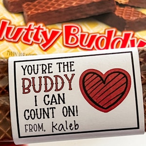 May include: A white card with a red heart and the text "You're the Buddy I can count on! From, Kaleb" attached to a chocolate bar.