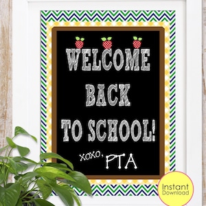 May include: A framed chalkboard-style sign with the text "WELCOME BACK TO SCHOOL!" in white chalk lettering. The sign features red apple illustrations and is bordered with a green, yellow, and blue chevron pattern. The sign also includes the text "xoxo, PTA".