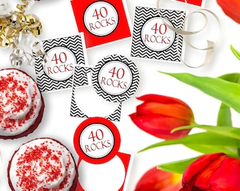 Peut inclure: Un ensemble d'étiquettes en papier carrées et circulaires portant l'inscription 40 ROCKS en rouge, présentées avec deux cupcakes au glaçage blanc et vermicelles rouges, des rubans dorés et un bouquet de tulipes rouges éclatantes.