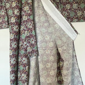 May include: A traditional Japanese kimono with a floral pattern in shades of purple, green, and white. The kimono is made of a soft, lightweight fabric and has a long, flowing silhouette.