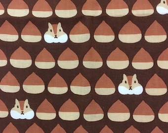 Può includere: Tessuto marrone con un motivo ripetuto di ghiande marroni e beige e scoiattoli di cartoni animati bianchi.