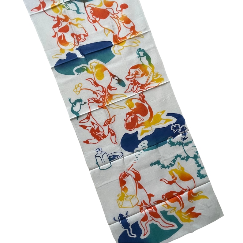 May include: White fabric with a colorful design of fish, frogs, and other creatures. The design is in shades of red, orange, yellow, blue, and green.