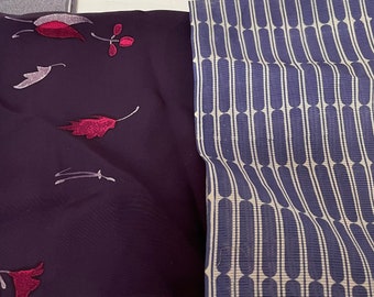 May include: Two fabric swatches, one with a dark purple background and a floral pattern in shades of pink and white, and the other with a white background and a blue and white striped pattern.