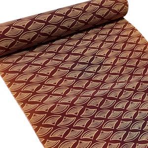 May include: A roll of fabric with a repeating pattern of gold geometric shapes on a burgundy background.