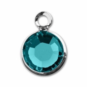 May include: A teal blue crystal charm with a silver loop for attaching to jewelry or other crafts.