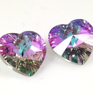 May include: Two iridescent heart-shaped crystal pendants with a hole at the top for hanging. The crystals are a mix of purple, pink, blue, and green.