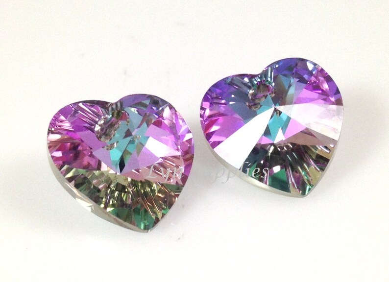 May include: Two iridescent heart-shaped crystal pendants with a hole at the top for hanging. The crystals are a mix of purple, pink, blue, and green.