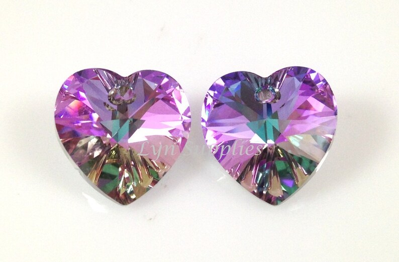 May include: Two iridescent purple heart-shaped crystal pendants with a silver loop at the top.