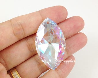 May include: A large, clear crystal teardrop pendant with iridescent rainbow facets. The pendant has a hole at the top for hanging.