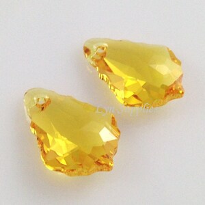 Puede incluir: Dos colgantes de cristal amarillo en forma de l&aacute;grima con un dise&ntilde;o facetado. Los colgantes tienen un agujero en la parte superior para colgar.