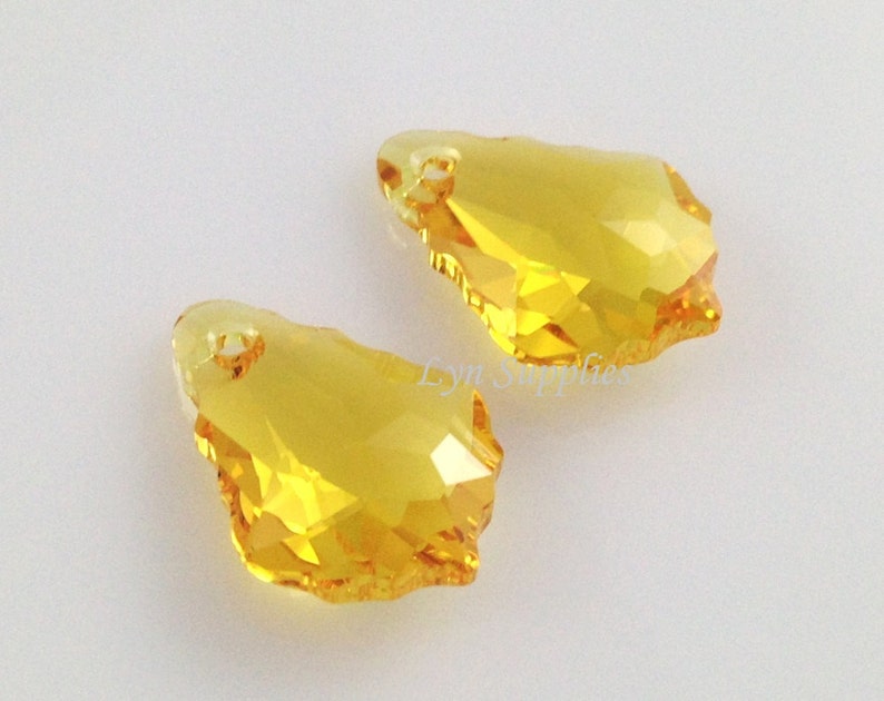 Puede incluir: Dos colgantes de cristal amarillo en forma de l&aacute;grima con un dise&ntilde;o facetado. Los colgantes tienen un agujero en la parte superior para colgar.