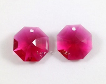 Puede incluir: Dos colgantes de cristal de forma octogonal rosa con un agujero en la parte superior para colgar.