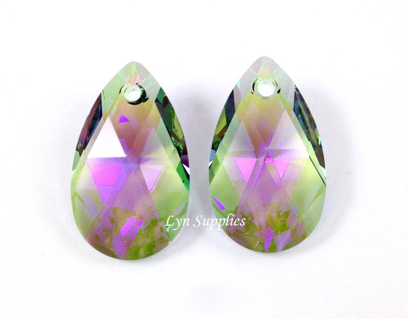 Peut inclure: Deux pendentifs en cristal en forme de goutte avec une finition iris&eacute;e. Les cristaux sont transparents avec un reflet vert, rose et violet. Les cristaux ont un trou en haut pour la ficelle.