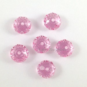 May include: Six pink faceted crystal beads with a hole in the center. The beads are approximately 10mm in diameter.