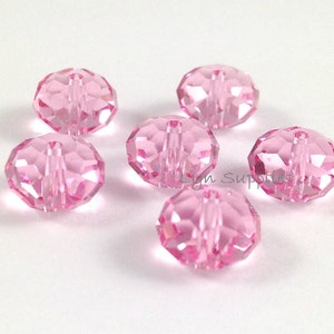 May include: Six pink crystal beads with a hole through the center. The beads are faceted and have a shiny finish.