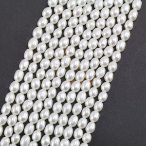 Puede incluir: Una hebra de perlas de agua dulce de forma ovalada y color blanco. Las perlas son lisas y brillantes.