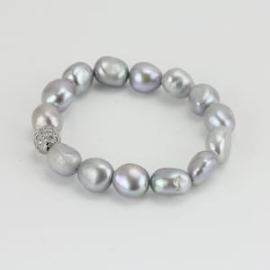 May include: A silver pearl bracelet with a silver and clear crystal bead clasp.