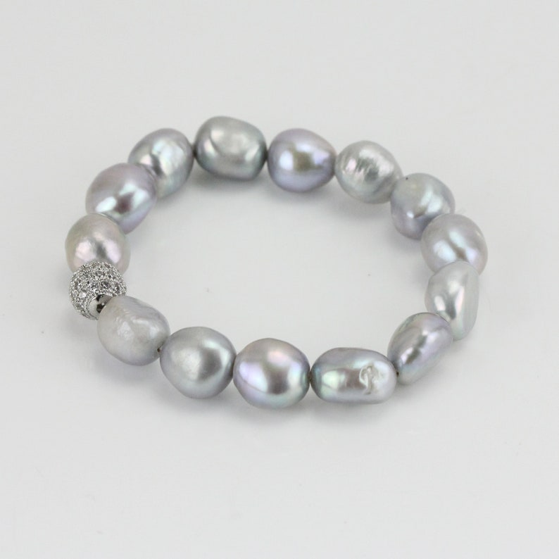 May include: A silver pearl bracelet with a silver and clear crystal bead clasp.