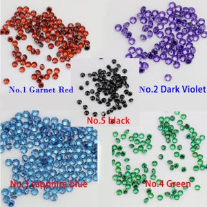 Pode incluir: Conjunto de pequenas pedras de strass redondas e facetadas em v&aacute;rias cores, incluindo vermelho granada, violeta escuro, azul safira, verde e preto.  No.1 Vermelho granada, No.2 Violeta escuro, No.3 Azul safira, No.4 Verde, No.5 Preto.