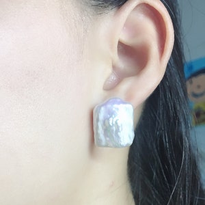 Puede incluir: Un par de pendientes de perlas barrocas blancas. Las perlas son grandes y tienen una forma irregular. Los pendientes son una pieza llamativa y serían perfectos para una ocasión especial.