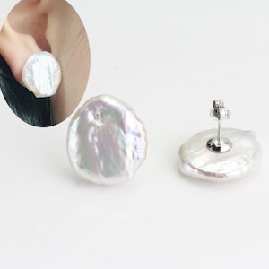 May include: A pair of white pearl earrings with a silver post and butterfly back. The pearls are irregular in shape and have a slight iridescent sheen.