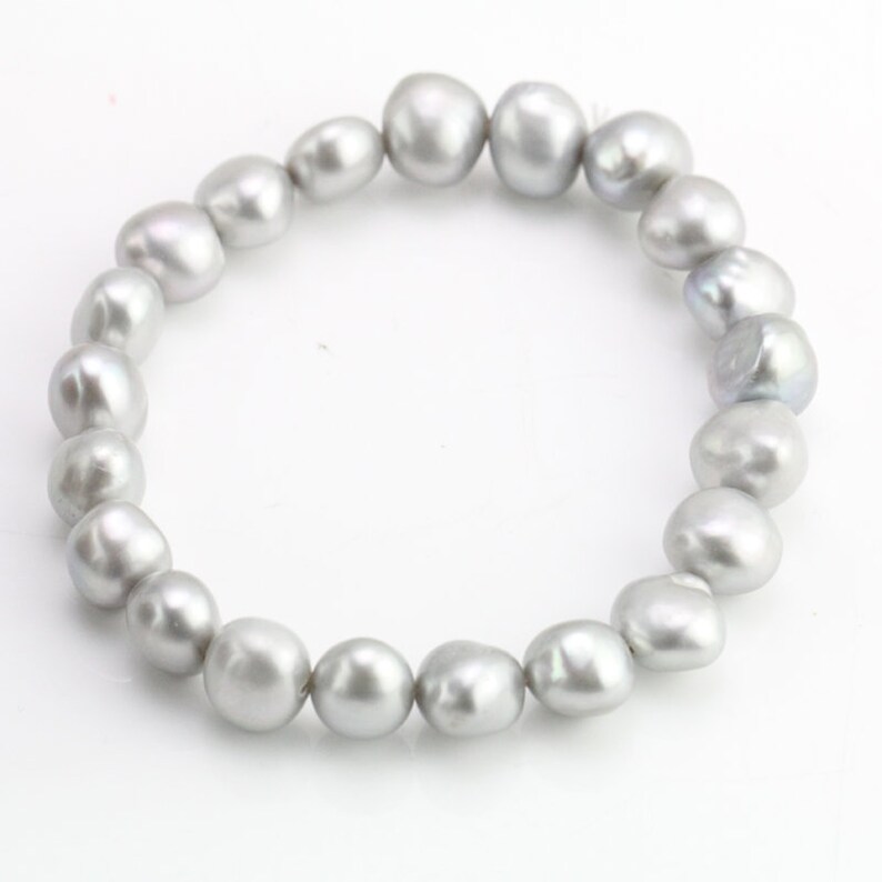 May include: A bracelet made of a strand of gray pearls.
