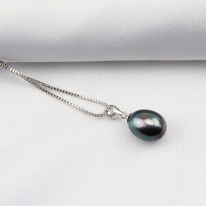 May include: A silver chain necklace with a dark gray pearl pendant.