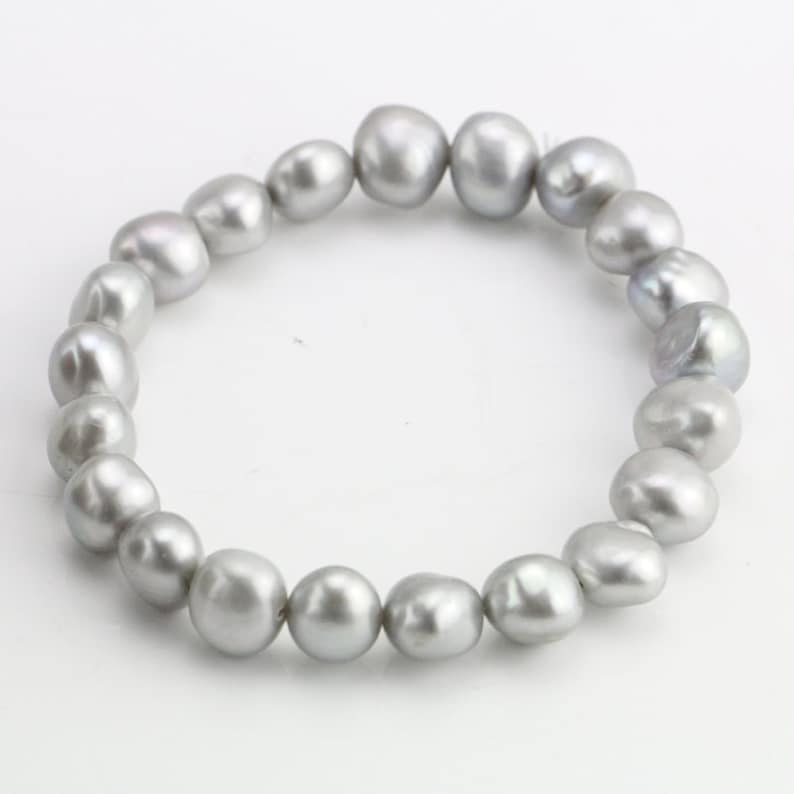 May include: A silver pearl bracelet with a strand of round, irregular pearls.