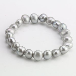 May include: A silver pearl bracelet with a simple design. The bracelet is made of a string of round, smooth pearls.
