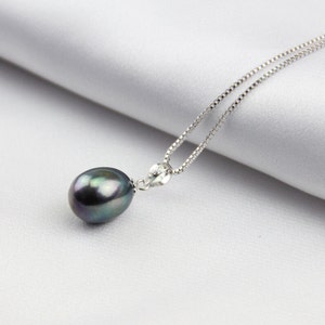 May include: A silver chain necklace with a single large black pearl pendant.