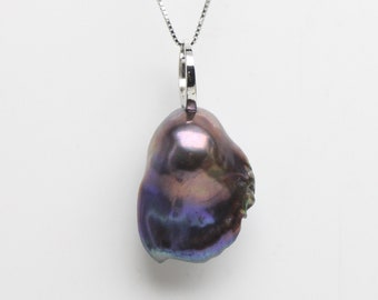 May include: A dark, iridescent baroque pearl pendant hangs from a delicate silver chain. The pearl displays a mix of purple, blue, and green hues, with a unique, organic shape. The pendant is suspended from a silver bail.