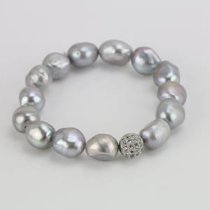 May include: A silver pearl bracelet with a silver and crystal bead in the center.