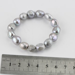 May include: A silver pearl bracelet with a silver and clear crystal bead. The bracelet is 7 inches long and is made of 12 pearls.