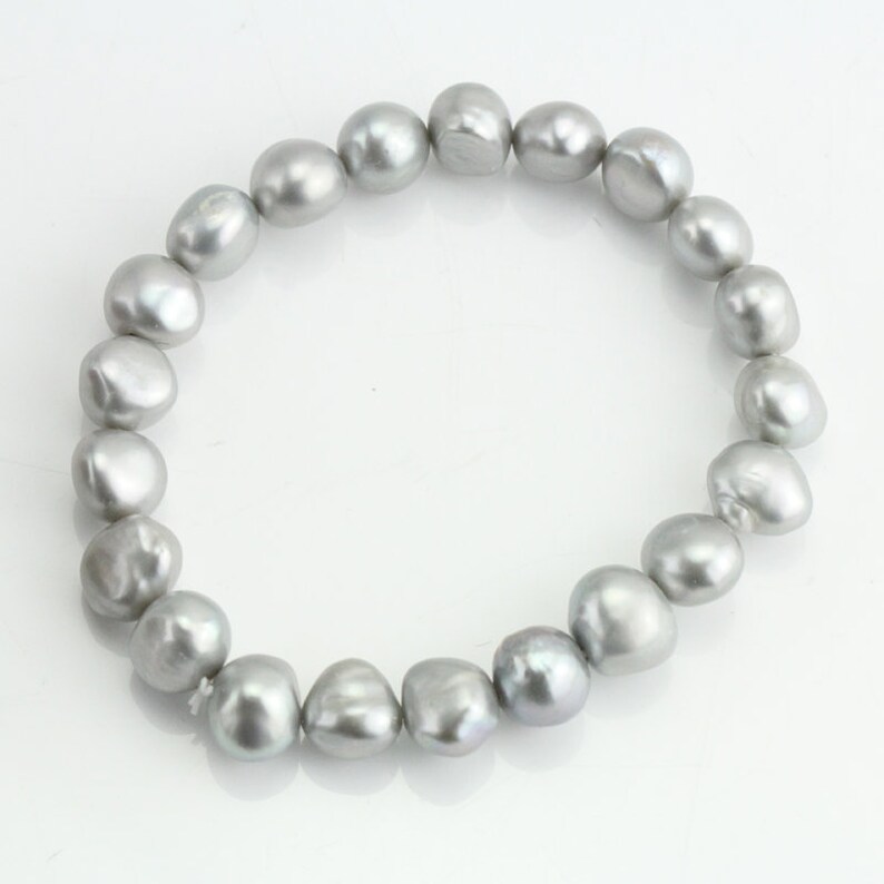 May include: A silver pearl bracelet with a strand of round, irregular pearls.