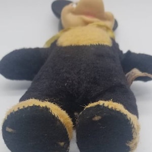 May include: A vintage plush Mickey Mouse toy with black fur, yellow felt accents, and a black felt nose. The toy has a stitched smile and is in good condition.