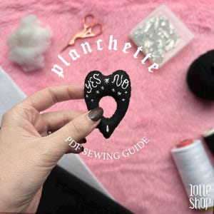 Può includere: Planchette in feltro nero con le parole "YES" e "NO" ricamate in bianco, insieme a dettagli a stella. L'immagine include il testo "PDF SEWING GUIDE" e "planchette". Sono presenti anche forbici, filo e imbottitura.