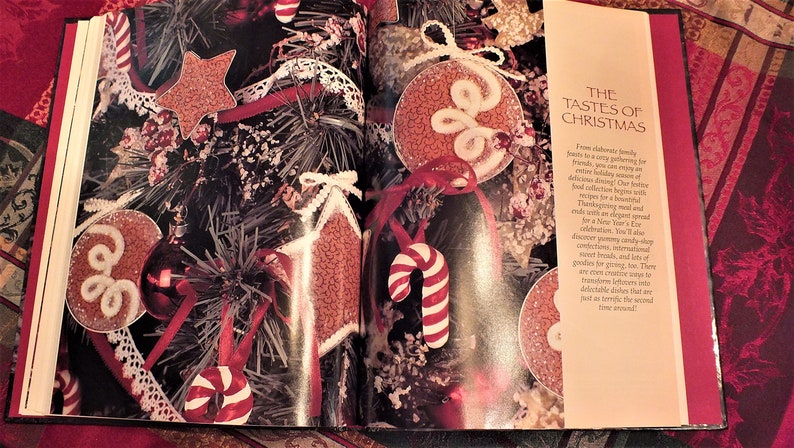 May include: A book titled "The Tastes of Christmas" with a red and white candy cane, a red and white star, and a red and white ornament on the cover. The book is open to a page with a close-up of the ornaments.