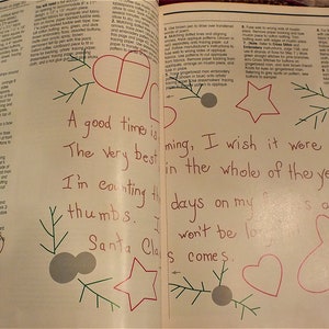 May include: A page from a book with a handwritten message about counting down the days until Christmas. The message is surrounded by hand-drawn illustrations of a gingerbread man, a star, a heart, and a Christmas tree.