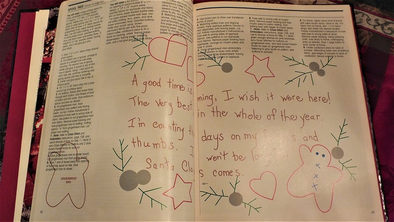 May include: A page from a book with a handwritten message about counting down the days until Christmas. The message is surrounded by hand-drawn illustrations of a gingerbread man, a star, a heart, and a Christmas tree.